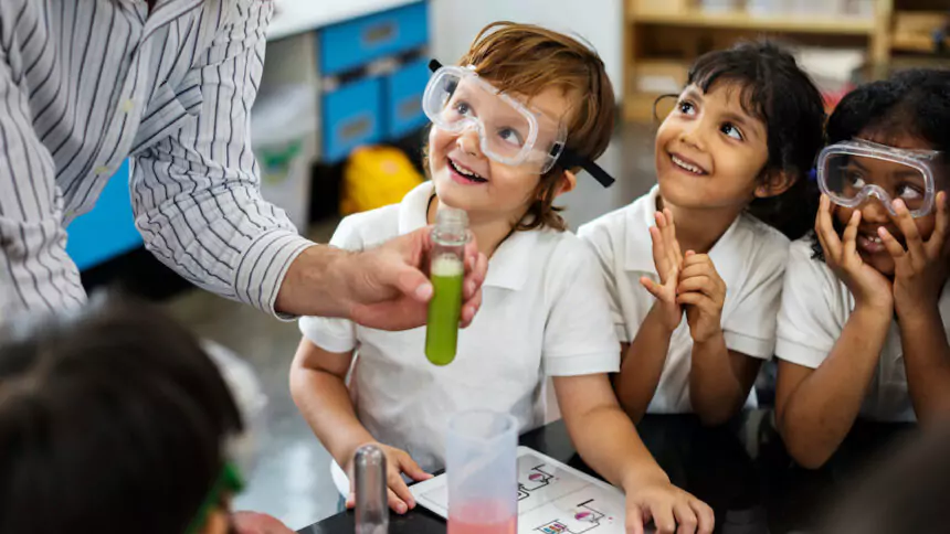 School children in uniforms learning about chemistry at school
